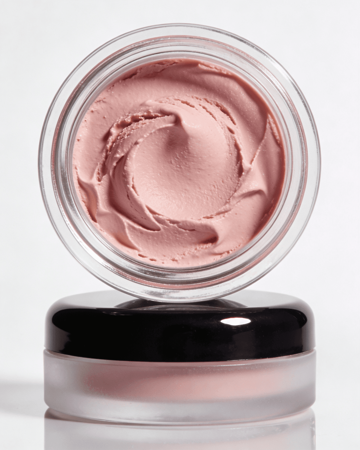 Glass jar of pink whipped moisturizer with a black lid